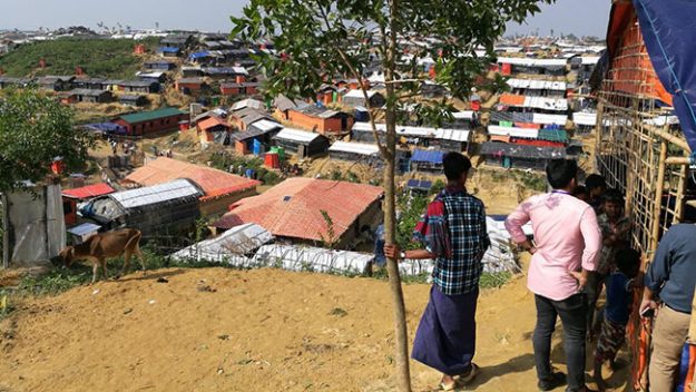 Image of Rohingya looking at housing in refugee camp