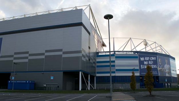 A metal stadium in front of a setting sun