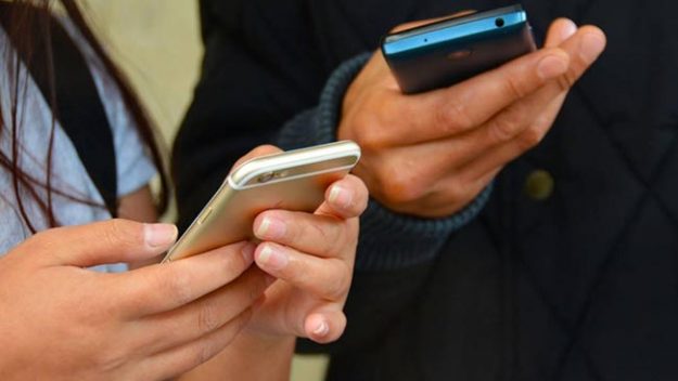 Two people's hands holding phones