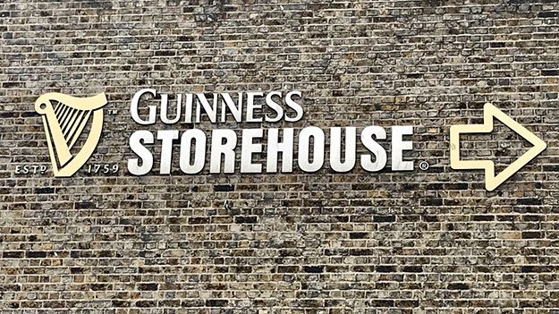A sign on a brick wall reading Guinness Storehouse, part of St Patrick's Day festivities