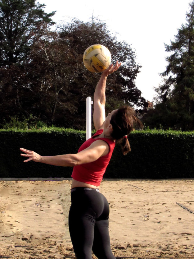 the female player is hitting the ball by jumping up