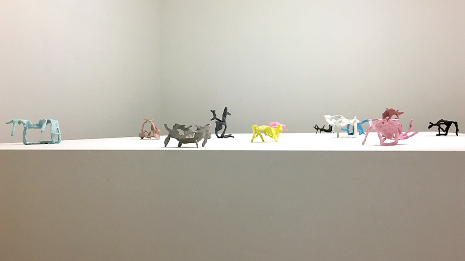 Colourful sculptures by Garth Evans on a white table.