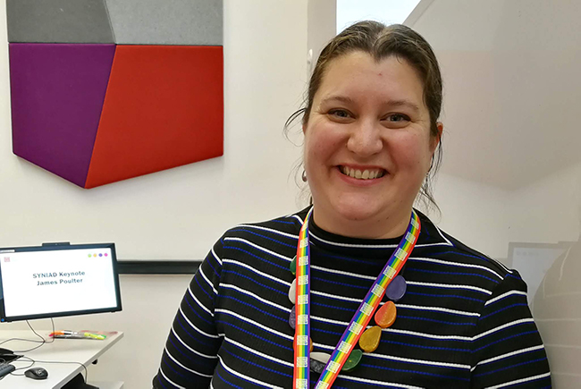 smiling woman with computer monitor in background