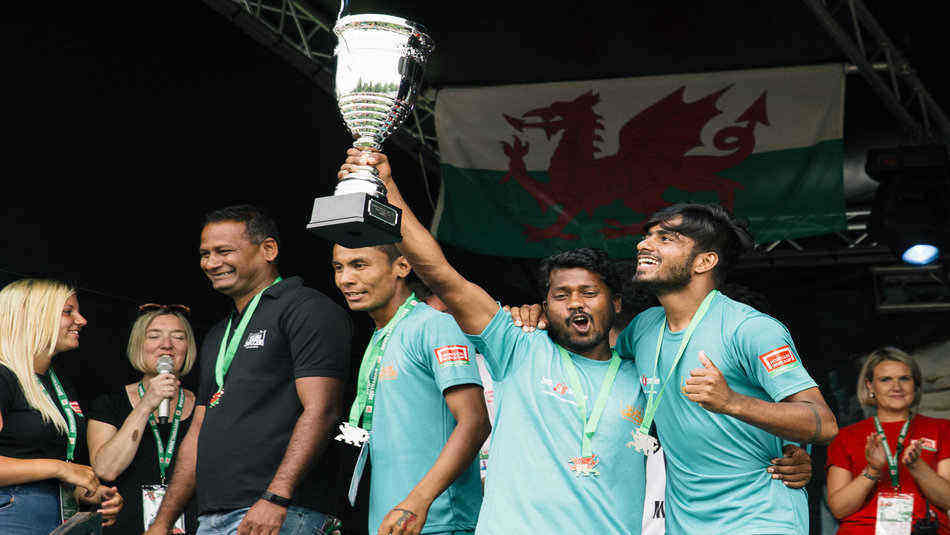 Team of homeless players from India hold their tier trophy.