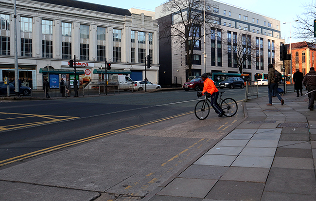 Cyclist in Cardiff busy roads, a good way to mitigate climate crisis.