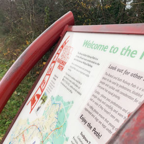 A red sign that says welcome to the path, with information on the path