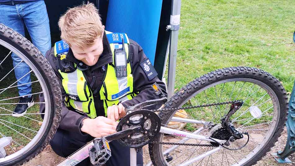 PCSO William Davies attaching security tags to a bike.