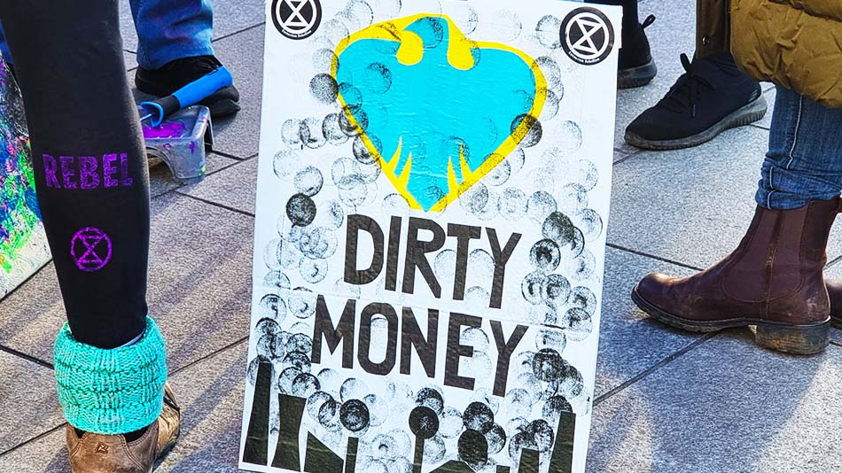 white placard saying "dirty money"
