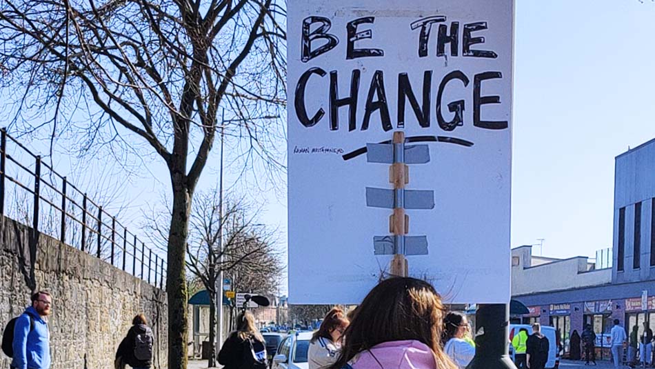 Placard saying "Be The Change"