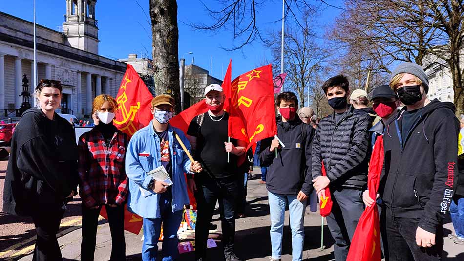 Members of the Young Communist League with red flags with symbols of the Hammer and Sickle and the Soviet star