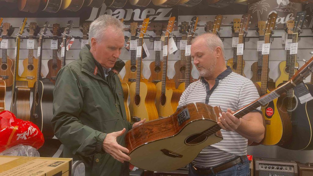 GM Music owner, Jake, is introducing the hidden details of  a new guitar to his potential guest.
