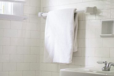 A picture of white towels hanging in a bathroom