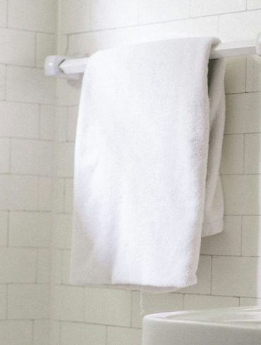 A picture of white towels hanging in a bathroom