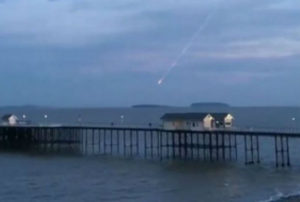A still from the footage shows a meteor crash into the sea near Penarth Pier.