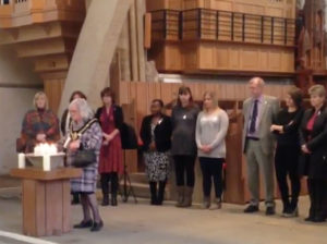 Lord Mayor of Cardiff councillor Monica Walsh lighting a candle in Llandaff Cathedral for White Ribbon Day