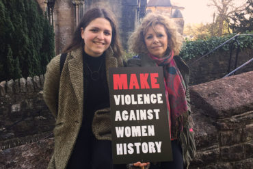 Two protesters stood outside Llandaff Cathedral with placard after the march