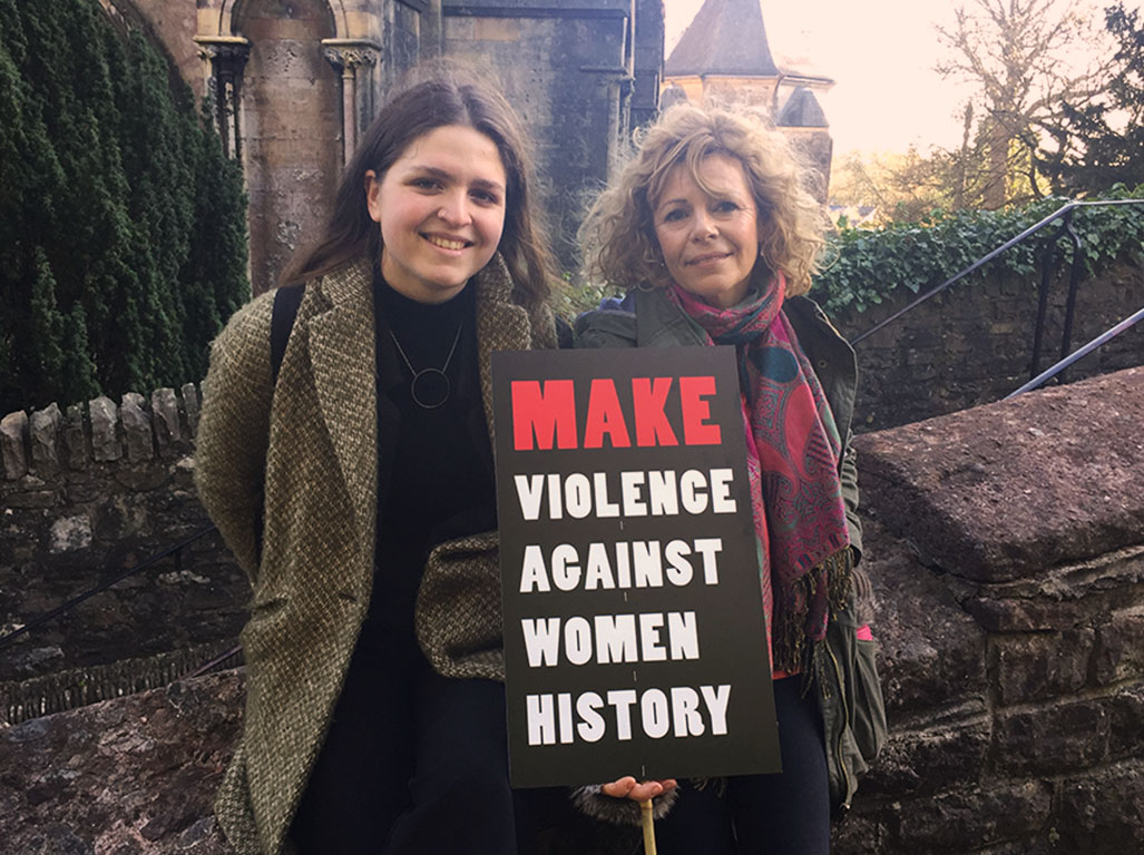 Two protesters stood outside Llandaff Cathedral with placard after the march