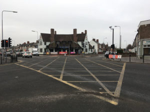 There are black railings on each side of the crossroads, but not outside the Birchgrove pub