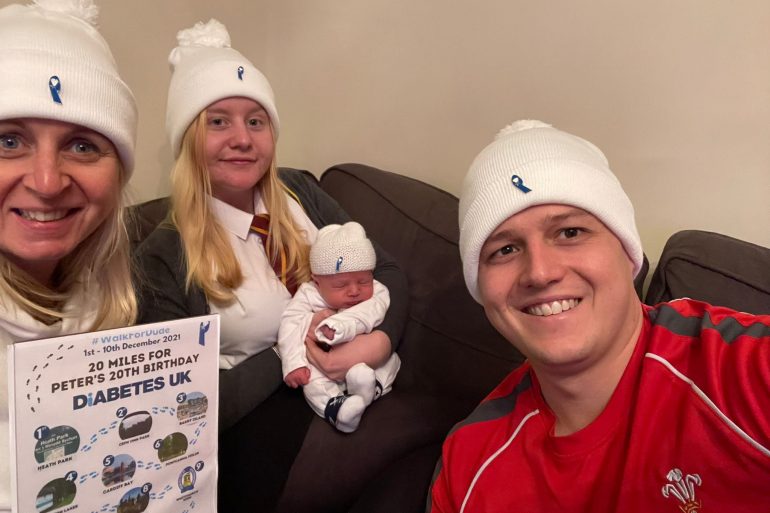 Beth Baldwin sits with her family wearing #WalkForDude hats