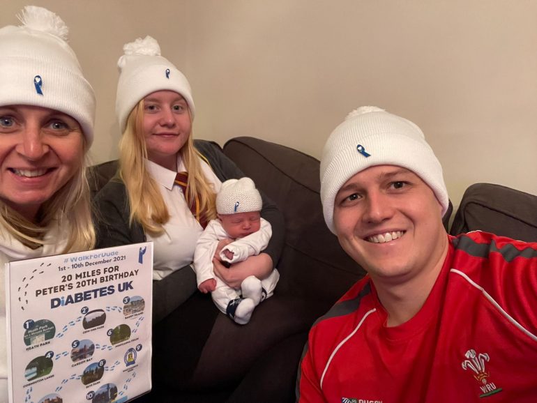 Beth Baldwin sits with her family wearing #WalkForDude hats