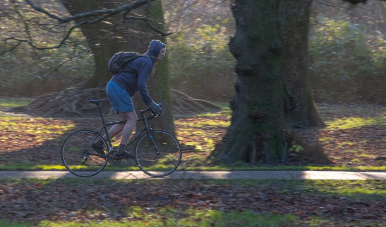 Man cycling through Bute Park