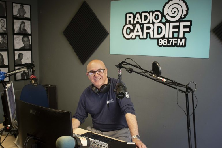 Ceri Stennett, one of Radio Cardiff's broadcasters, sitting in the studio with his radio equipment
