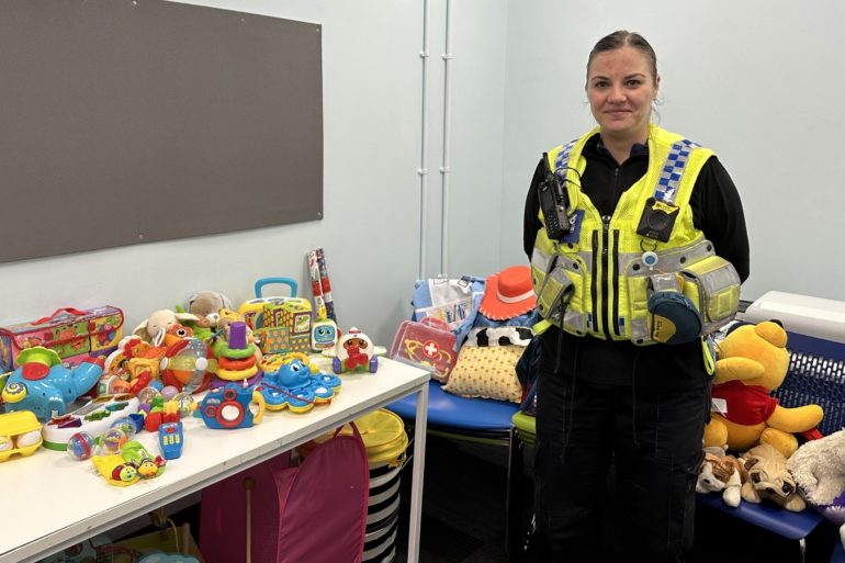 PCSO Kylie Barclay standing next to tables filled with children's toys