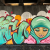 A mural of a girl wearing a hijab with the word 'unity' on a concrete wall