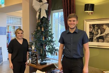 Carys and Mason from Coopers Carvery stand next to their gift tree.