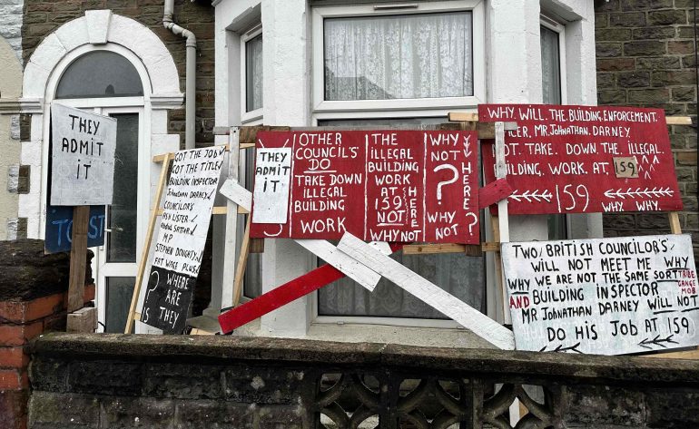 Signs outside Mr Taylor's home claiming illegal building work was undertaken nextdoor