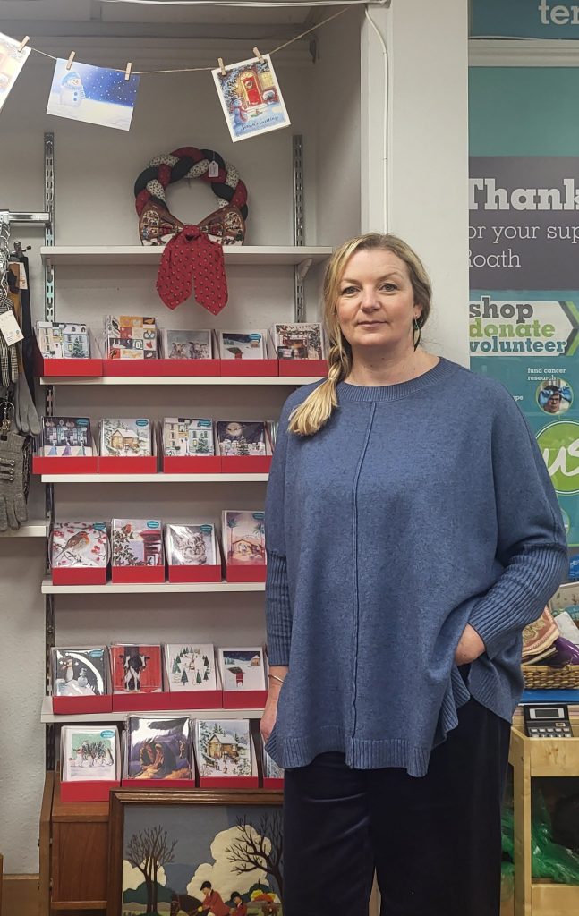 Woman standing next to shelves of Christmas Cards