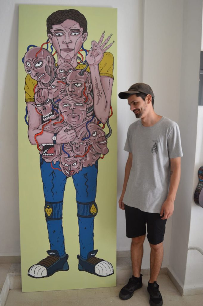 Lazaros with another of his paintings. Image credit: Chrisoula Konstantakou