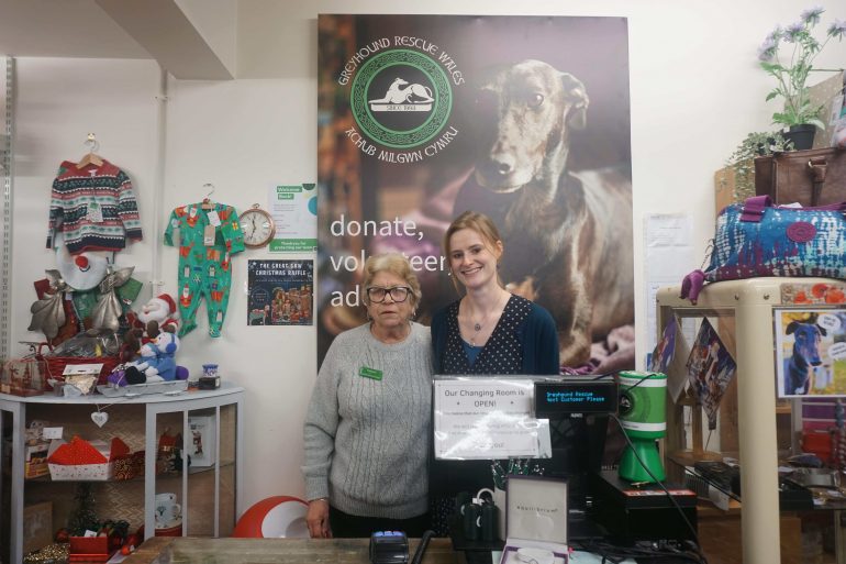 two women standing behind a shop counter