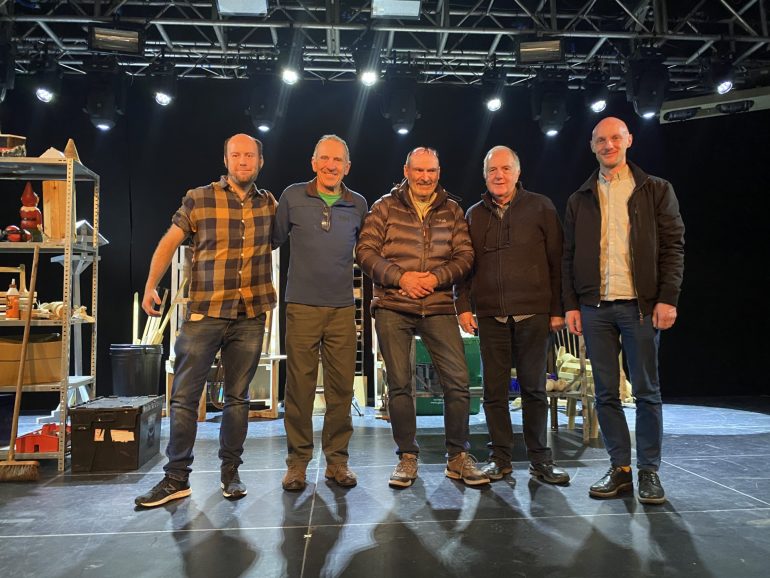 five men standing together on a stage