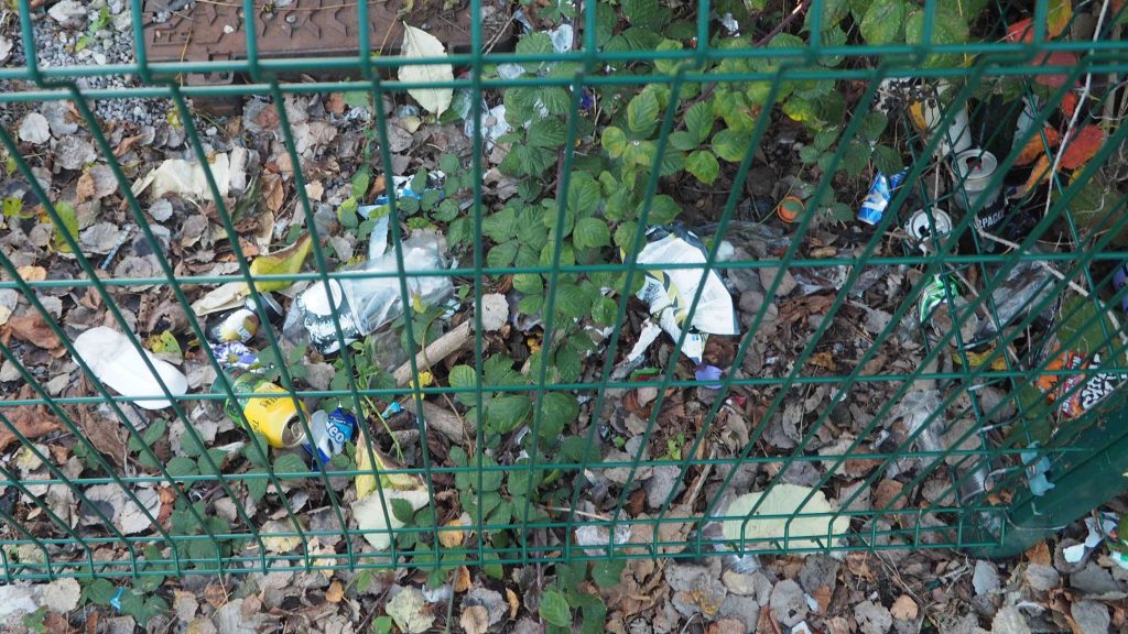 The image shows litter within the fence of the site.