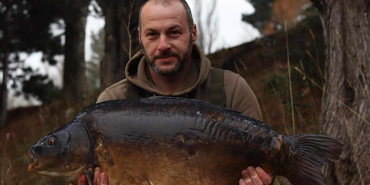 A man looking proud holding a huge fish up.