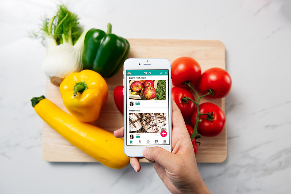 The app Olio on display over a chopping board of colourful vegetables